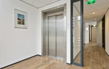 Interior view of an office space at Welbergweg 60, Hengelo featuring a modern elevator and hallway, suggesting office space rental opportunities.