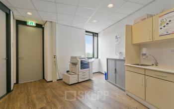Interior view of an office space at Welbergweg 60, Hengelo, featuring a printer and a small kitchenette. Ideal for office space rental.