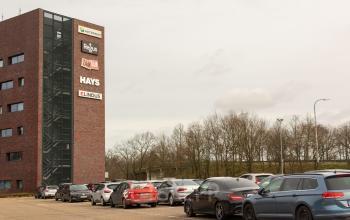 Exterior view of office building at Atealaan 34A in Herentals with multiple cars parked in the lot. Office space rental available.