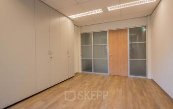 Unfurnished office space at Mozartlaan 25, Hilversum, with wood-style flooring and built-in cabinets, perfect for office space rental.
