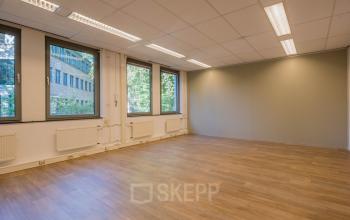 Bright and spacious office to rent at Mozartlaan 25, Hilversum, featuring wooden floors and large windows offering natural light, suitable for office space rental.