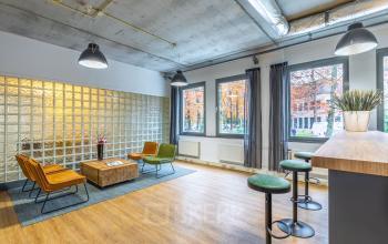 Bright office space for rent at Mozartlaan 25, Hilversum, featuring modern furnishings, glass wall, and ample natural light, ideal for office space rental.