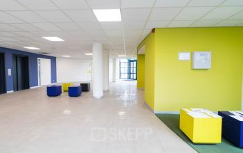 Spacious and bright entrance area at Franciscusweg 219 in Hilversum with colorful seating, ideal for office space rental.