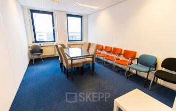 Office space rental at Franciscusweg 219, Hilversum. The room features a table with chairs, perfect for meetings or collaborative work. Large windows provide ample natural light, illuminating the office to rent.