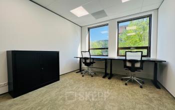 Bright office space at Marathon 2, Hilversum, featuring two desks with office chairs and a cabinet, ideal for office space rental.