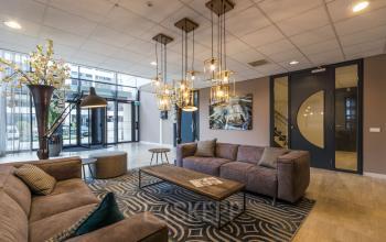 Furnished office lounge at Marathon 2 in Hilversum featuring comfortable seating and stylish lighting, an ideal office space rental option.