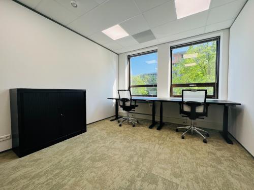 Bright office space at Marathon 2, Hilversum, featuring two desks with office chairs and a cabinet, ideal for office space rental.