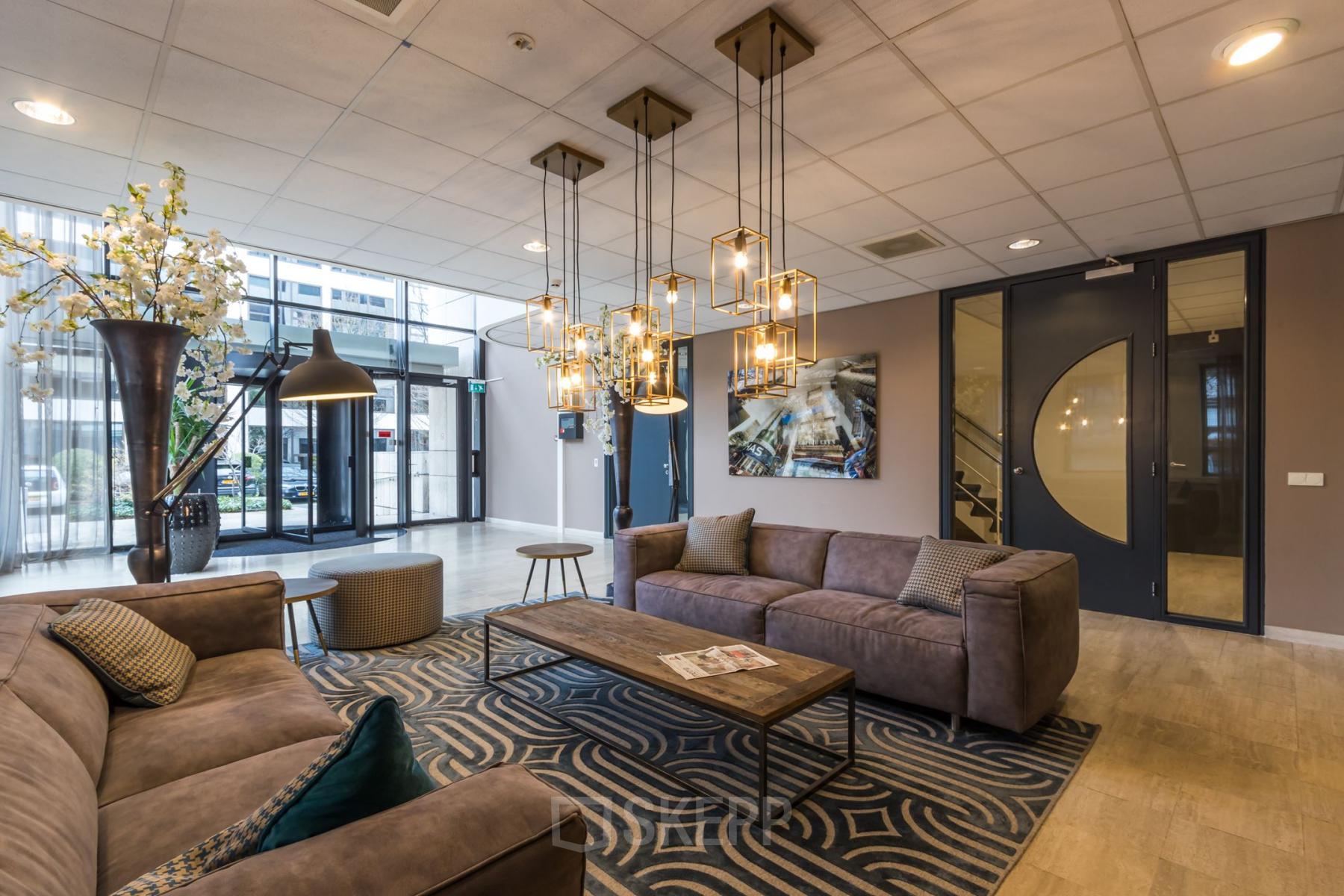 Furnished office lounge at Marathon 2 in Hilversum featuring comfortable seating and stylish lighting, an ideal office space rental option.