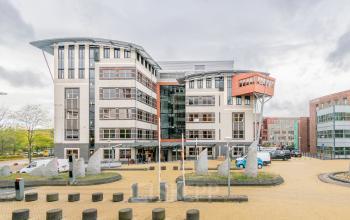 Modern, multi-story office building at Olympia 1, Hilversum, available for office space rental, with large windows and a central entrance.