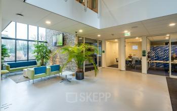 Modern office space at Olympia 4 in Hilversum featuring a bright interior with meeting rooms and contemporary seating areas. Ideal for office space rental with collaborative workspaces and a welcoming atmosphere.