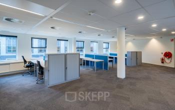 Office space rental at Olympia 4, Hilversum featuring an open floor plan with modern workstations, ample natural light, and minimalist furnishings ideal for a productive work environment.
