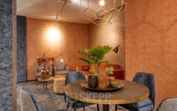 Cozy furnished office space for rent at Steijnlaan 16, Hilversum, featuring stylish seating and warm decor.