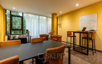 A bright and inviting office space with a meeting table, chairs, and a map on the wall at Steijnlaan 16, Hilversum. Ideal for office space rental.