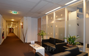 Modern office space rental at Olympia 2D, Hilversum featuring cozy lounge areas and transparent partitioned offices.