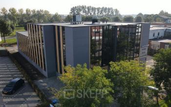 Exterior view of an office building at Catharina van Renneslaan 8-10, Hilversum, showcasing sleek design and reflective windows ideal for office space rental.