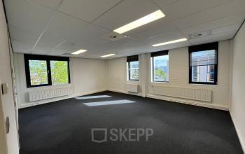 Bright, unfurnished office space available for rent at Catharina van Renneslaan 8-10 in Hilversum, featuring large windows and a clean, professional interior.