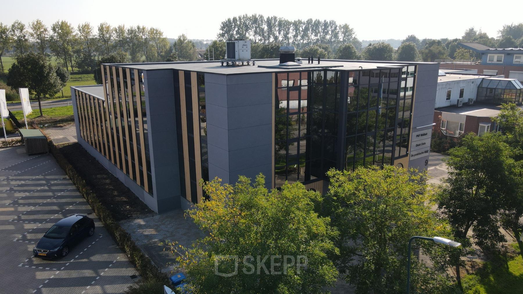 Exterior view of an office building at Catharina van Renneslaan 8-10, Hilversum, showcasing sleek design and reflective windows ideal for office space rental.