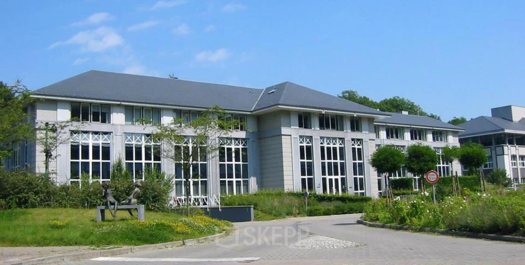 Exterior view of office building located at Terhulpsesteenweg 6A, Hoeilaart, featuring large windows and a well-maintained surrounding area, ideal for office space rental.
