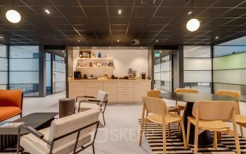 Furnished office space at De Wel 20, Hoevelaken, featuring modern seating and a kitchenette, ideal for rent office space needs.