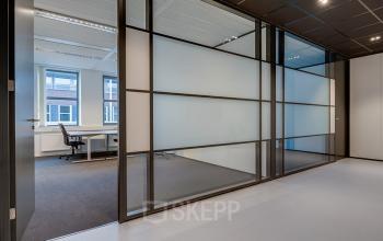 Modern office space to rent in Hoevelaken, featuring large windows and sleek glass partitions for a bright work environment.
