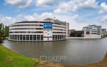 Modern office buildings at Polarisavenue 1, Hoofddorp, featuring glass exteriors surrounded by a water feature.
