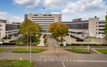 View of the office building at Polarisavenue 1, Hoofddorp, featuring its exterior with parking, modern architecture, and surrounding greenery. Ideal for businesses seeking office space rental in a prime location.