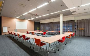 Spacious, well-lit U-shaped conference room with large windows and red chairs, located at Polarisavenue 1, Hoofddorp. Available for office space rental.