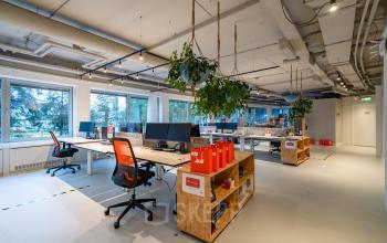 Modern office space with open floor plan, bright natural light, wooden shelves, and ergonomic chairs at Polarisavenue 1, Hoofddorp.