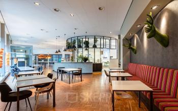 Modern and stylish office space rental at Polarisavenue 1 in Hoofddorp, featuring well-lit, creatively decorated workspaces with ample seating and contemporary furnishings.