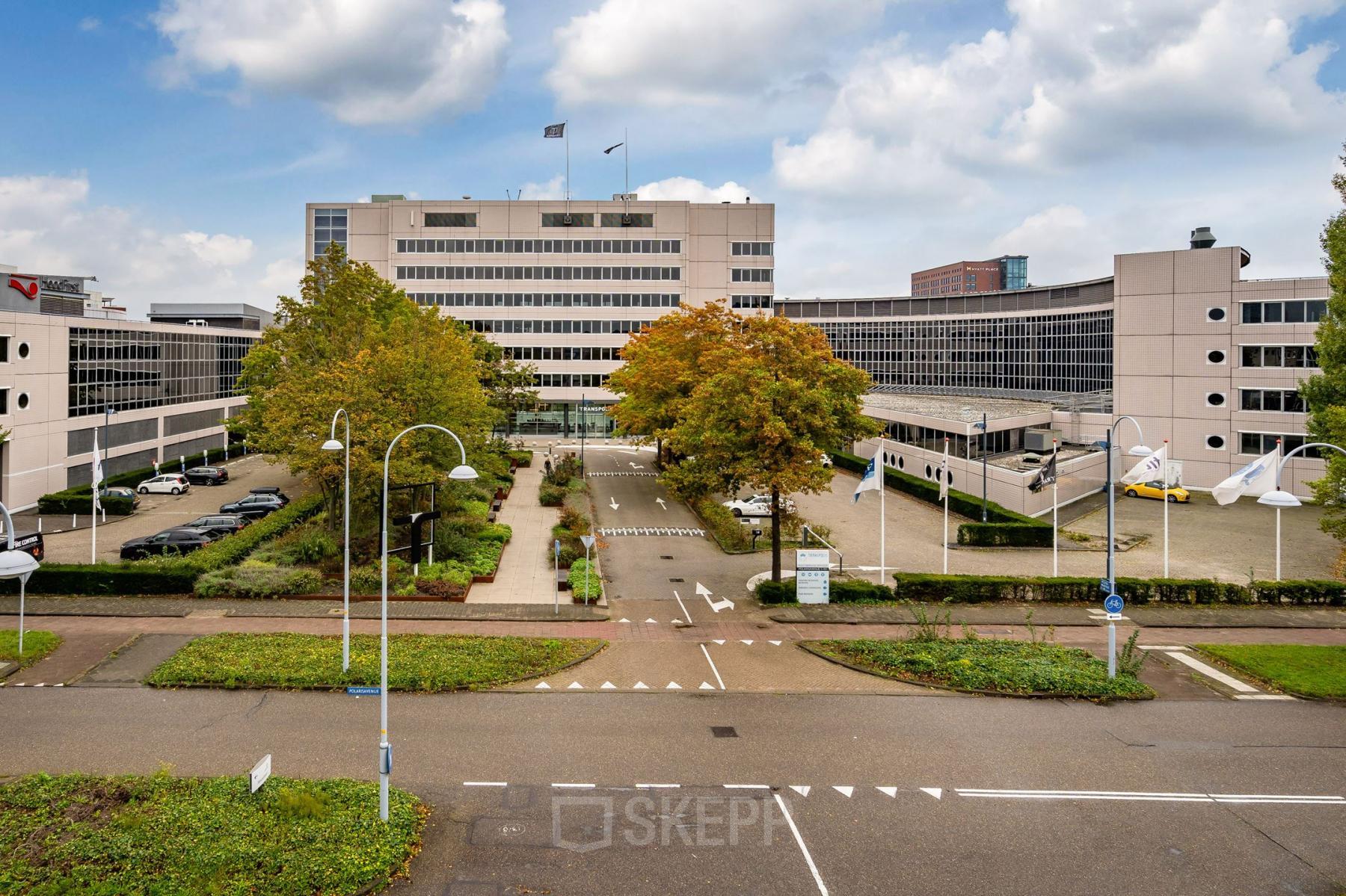View of the office building at Polarisavenue 1, Hoofddorp, featuring its exterior with parking, modern architecture, and surrounding greenery. Ideal for businesses seeking office space rental in a prime location.