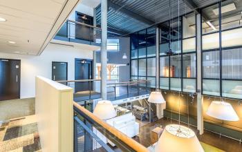 Spacious, well-lit office interior at Opaallaan 1180, Hoofddorp, ideal for office space rental, featuring a modern open-floor plan with large windows and stylish lighting.