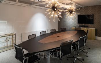 Modern conference room at Siriusdreef 60, Hoofddorp, featuring a stylish oval table, sleek chairs, and unique lighting fixtures. Ideal for office space rental, this setup encourages professional collaboration.