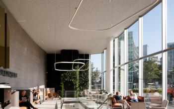 Modern office lounge at Taurusavenue 1-41, Hoofddorp, with sleek furnishings and large windows. People are seen relaxing. Ideal for those seeking office space rental in a bright environment.