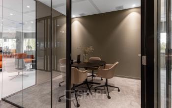 Modern furnished office space available for rent at Taurusavenue 1-41 in Hoofddorp, featuring a cozy meeting area with chairs and table.