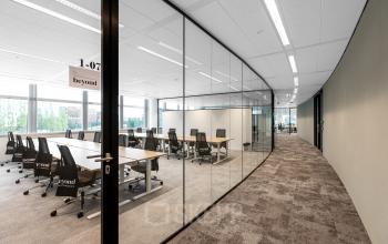 Interior view of modern furnished office space with glass walls and desks at Taurusavenue 1-41, ideal for office space rental in Hoofddorp.