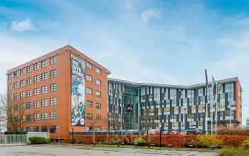 Exterior view of Siriusdreef 16 in Hoofddorp, featuring a modern office building with parking facilities. Ideal office space rental opportunity in a vibrant business environment.