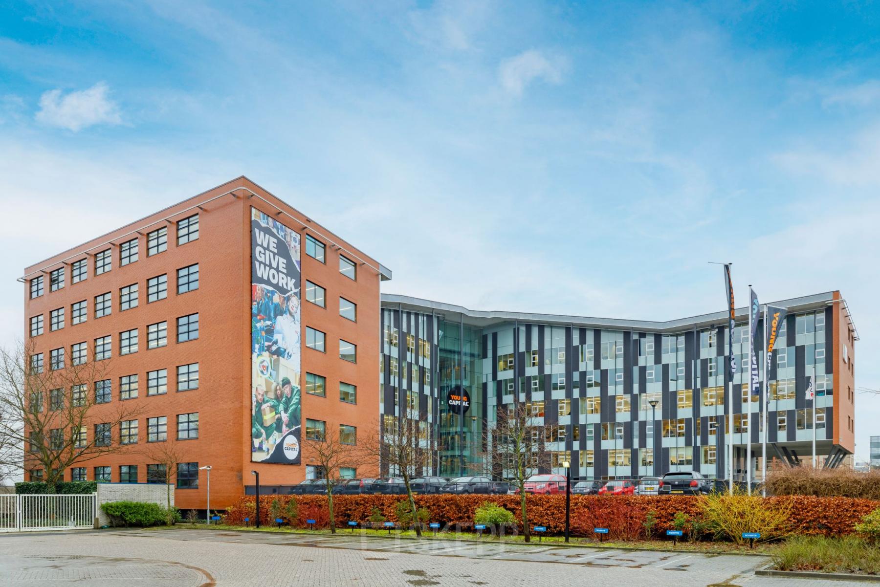 Exterior view of Siriusdreef 16 in Hoofddorp, featuring a modern office building with parking facilities. Ideal office space rental opportunity in a vibrant business environment.