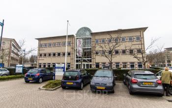 Exterior view of office space rental at Siriusdreef 17, Hoofddorp, showing the building facade with parked cars in front.