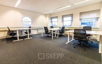 Modern office space rental at Siriusdreef 17, Hoofddorp, showcasing a well-lit room with multiple desks and chairs, ready for business productivity.
