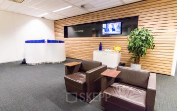 Welcoming reception area at Siriusdreef 17 Hoofddorp office space rental, with cozy seating and a warm wooden wall design.
