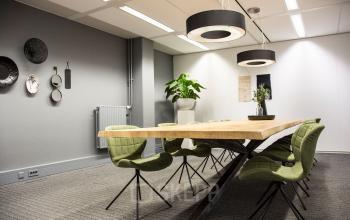 Spacious, well-lit office meeting room with wooden table and modern chairs at Meidoornkade 22, perfect for office space rental.