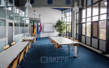 Spacious and well-lit conference room at Eurodepark 1, Kerkrade, featuring modern furniture, large windows for natural light, and presentation equipment, ideal for office space rental.