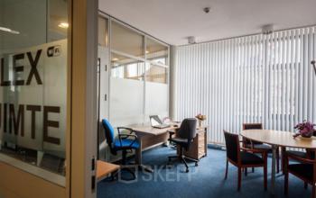 Office space rental at Eurodepark 1, Kerkrade featuring a room with desks, chairs, and a round table with flowers.
