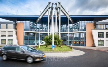 Front view of the office building at Eurodepark 1 in Kerkrade, showing modern architecture with large windows and a roundabout at the entrance.