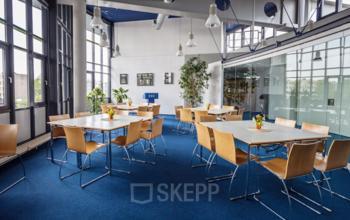 Open, furnished office space at Eurodepark 1 in Kerkrade, featuring modern furniture, large windows, and ample seating. Ideal for a variety of business activities.