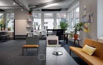 Bright workspace at Tunisstraße 19-23 in Cologne Center with modern furniture, large windows, and plants.