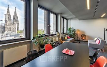 Modern furnished office space at Tunisstraße 19-23, Cologne Center, featuring large windows with a view of Cologne Cathedral and contemporary furniture.