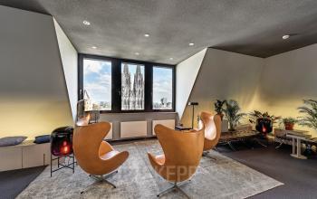 Office space rental in Cologne Center, featuring stylish leather chairs and a view of Cologne Cathedral from Tunisstraße 19-23.