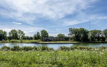 Exterior view of the office building located at Oudhuizerstraat 31, Klarenbeek, next to a river and surrounded by greenery. Ideal office space rental option.