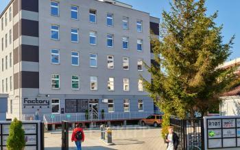 Nowoczesne biura na wynajem w Krakowie przy Przemyslowa 12 z widocznymi przechodniami przed budynkiem